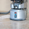 A large industrial-grade concrete flooring grinder sanding a concrete surface for epoxy resin installation.