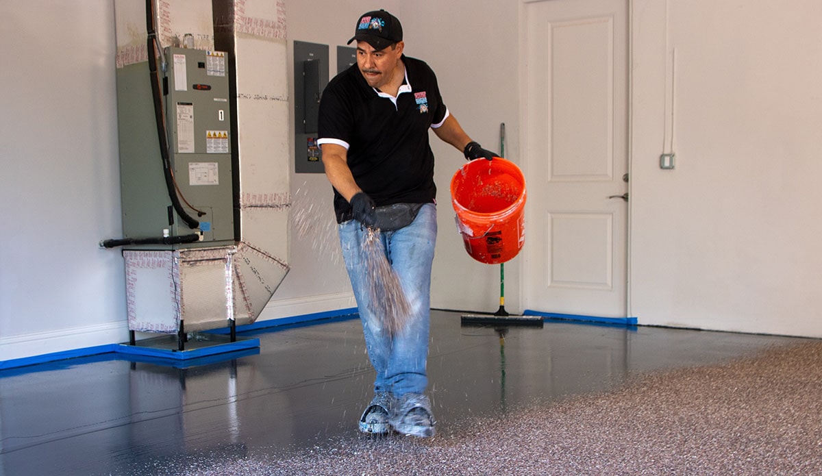 An epoxy resin contractor installing a flake epoxy resin garage floor in a residential space.