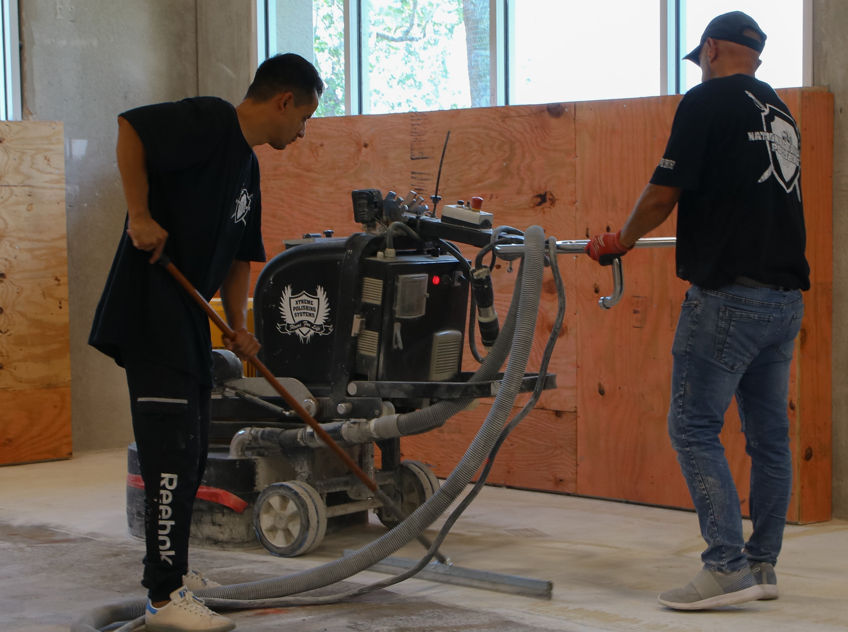A contractor operating a floor grinder to perform concrete preparation.