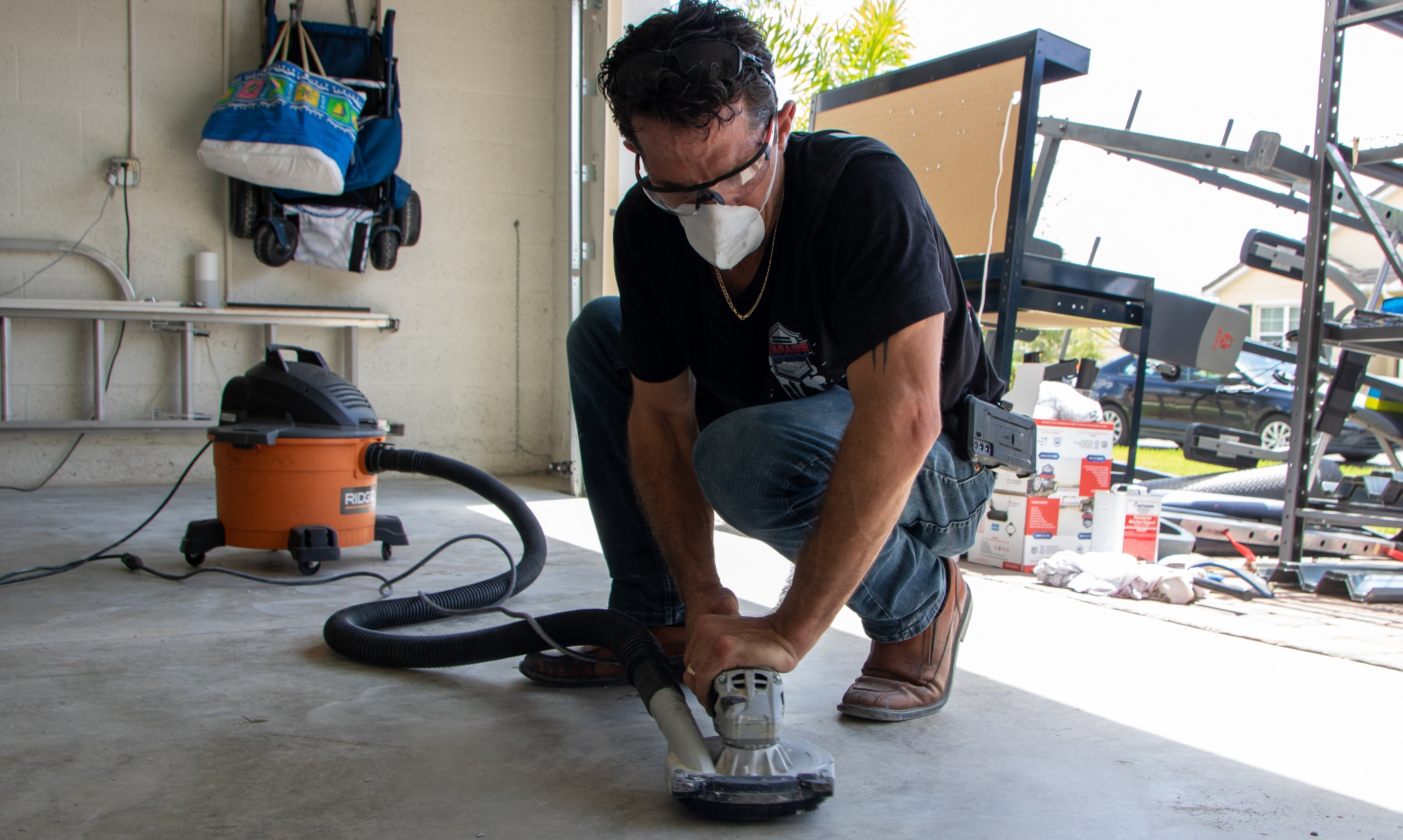 An epoxy flooring contractor smoothing out cracked concrete.