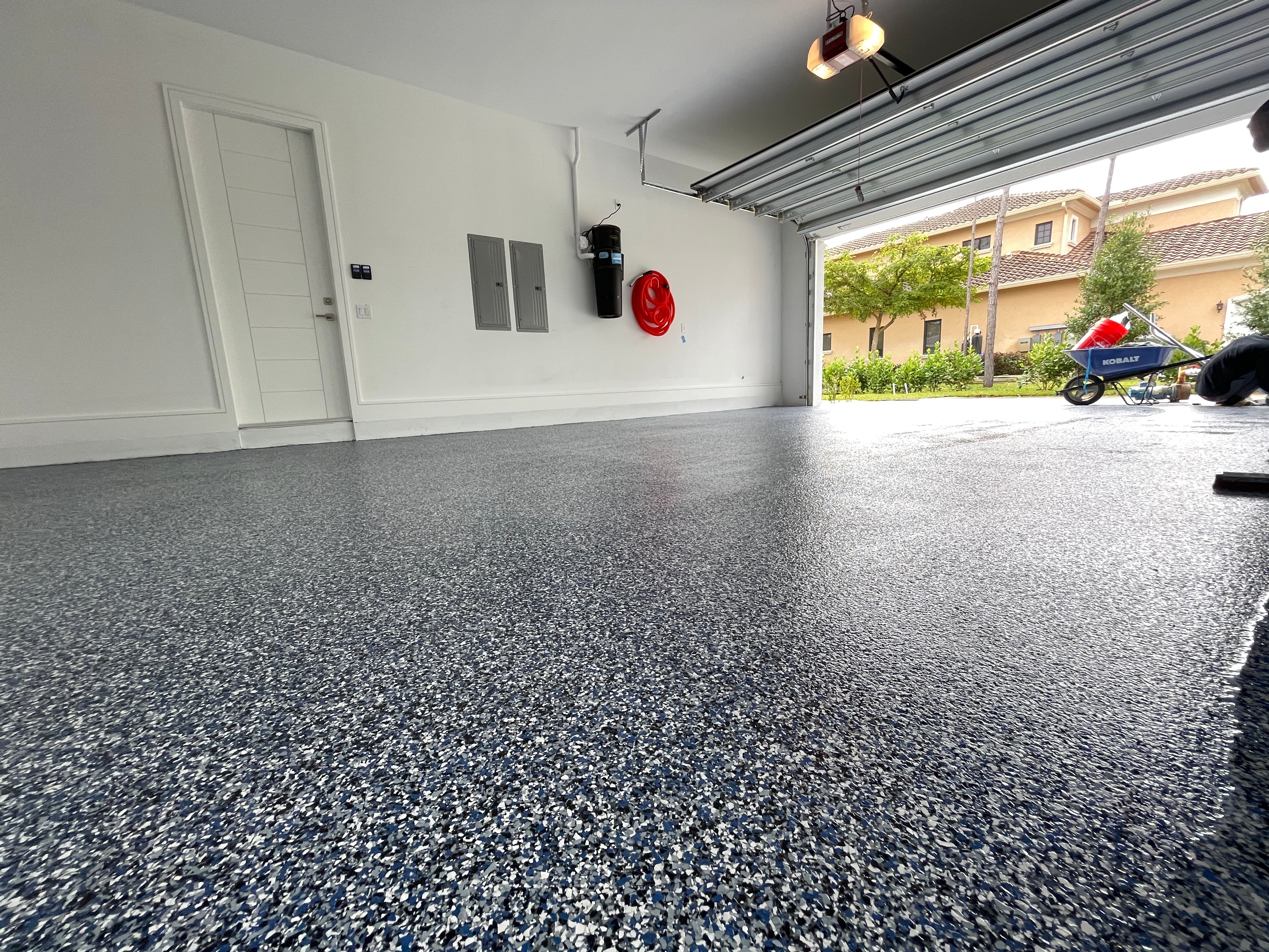 A vinyl flake epoxy resin garage flooring system installed in a residential garage.