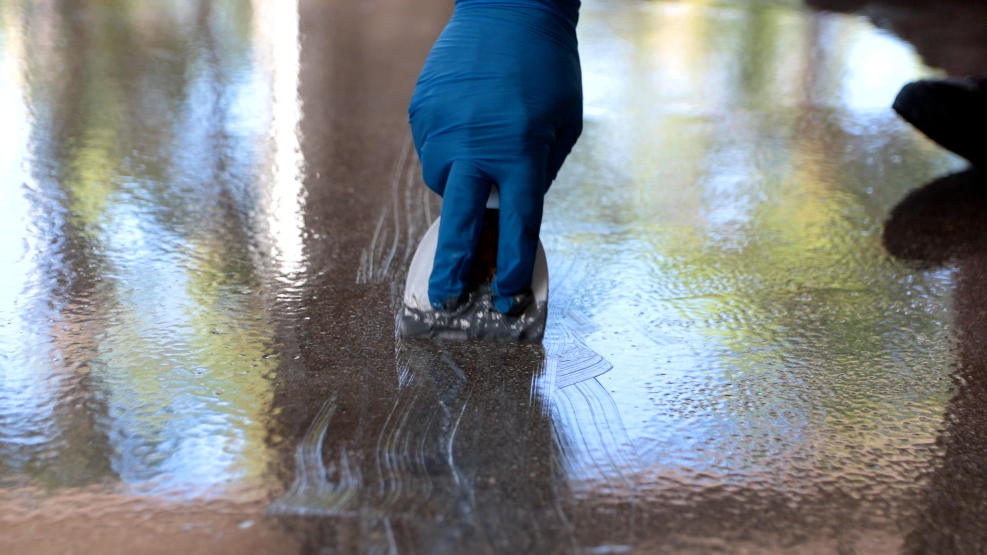 An epoxy resin contractor polishing a new floor with safety precautions.