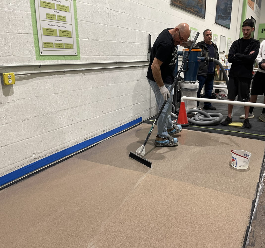man teaching epoxy flooring holding squeegee in hand | Epoxy ETC